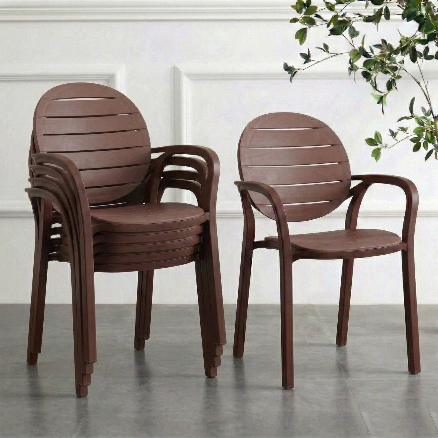 Stackable chocolate brown 6 chairs on a concrete floor with a white wall and plant in the background