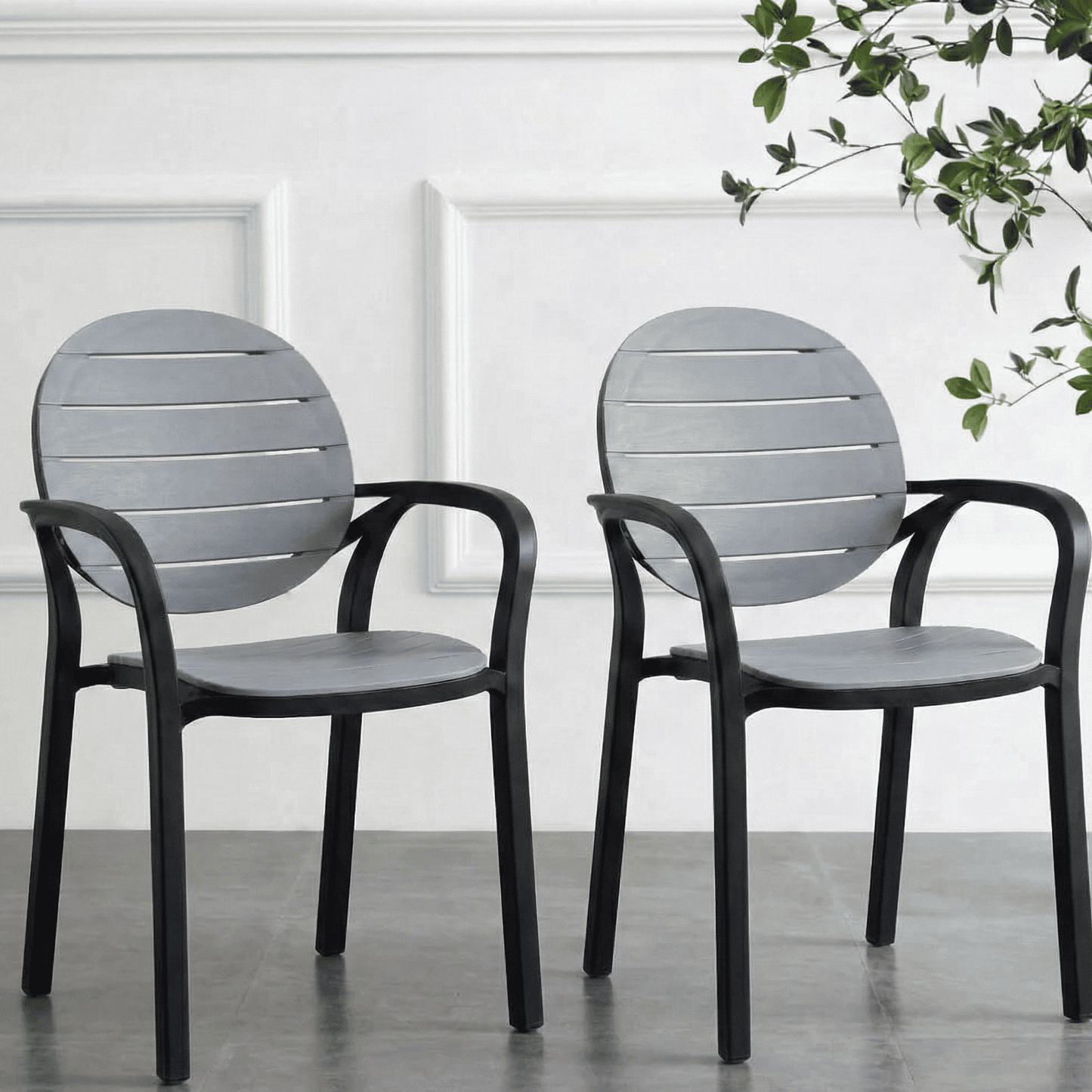 Two gray chairs with black frames on a concrete floor.

